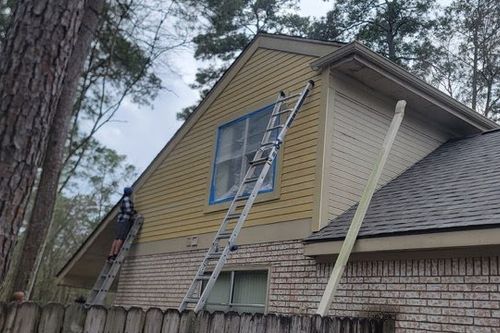Technicians masking windows before painting new Hardie siding in Willis, TX