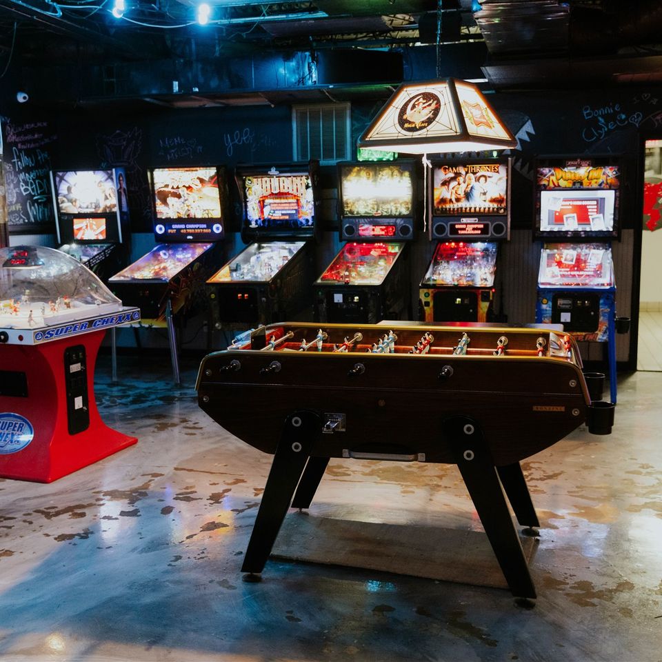 Foosball table with arcade machines in background