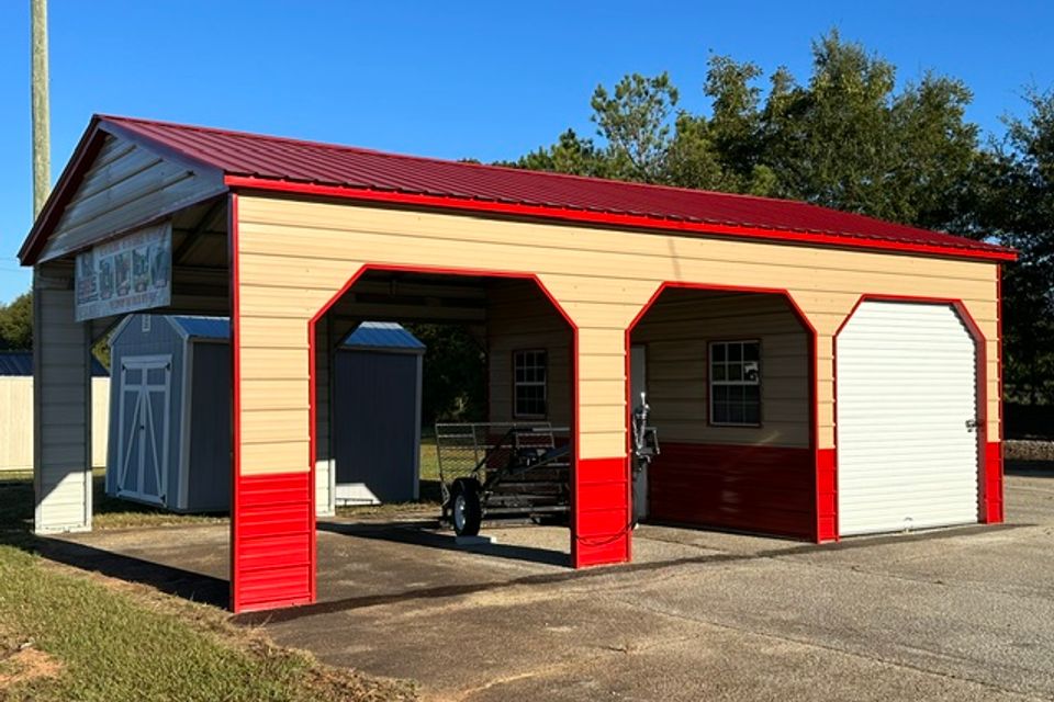 Tan and red steel utility carport with open bays and enclosed storage room representing steel carports in Alabama