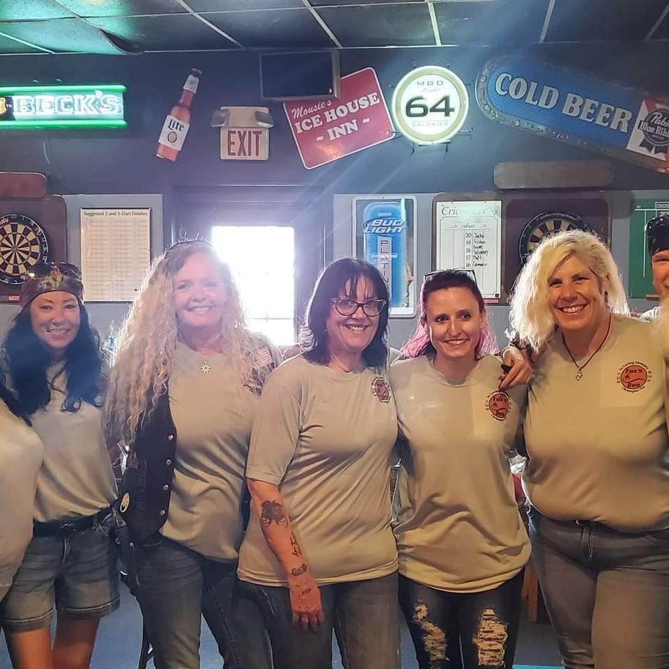 Group of men and women posing together inside a social club or event venue.