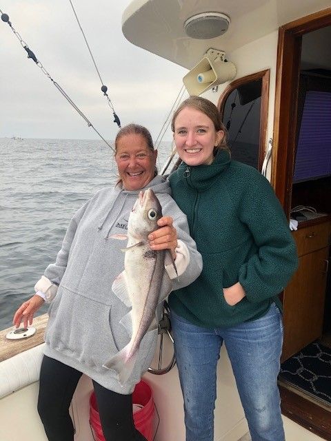 2 ladies on boat holding haddock