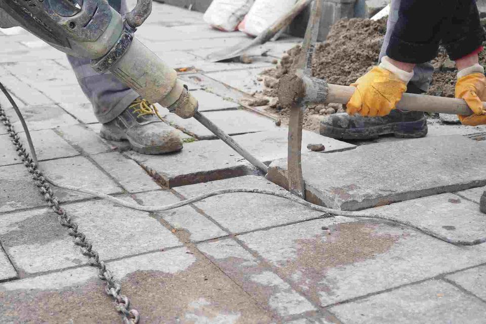 concrete workers cutting through concrete slabs