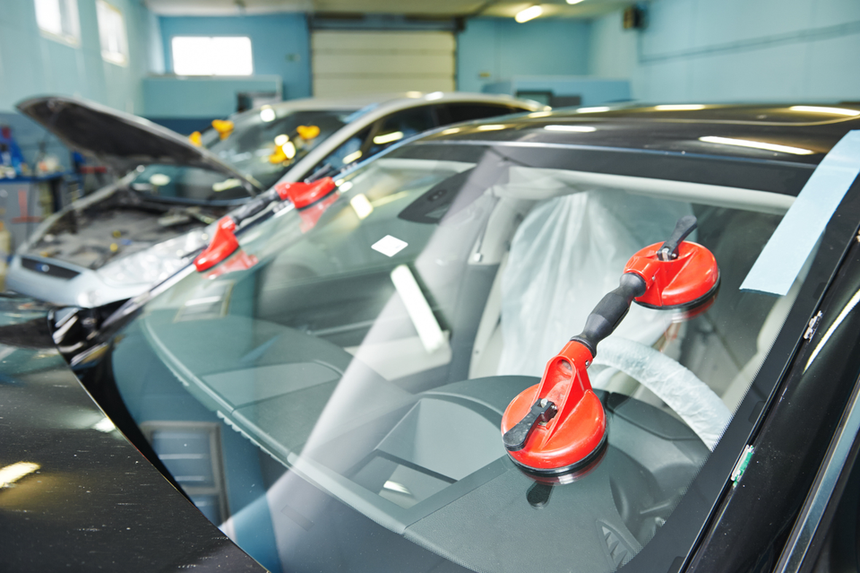 Newly installed vehicle windshield secured with professional installation tools during an auto glass replacement service.