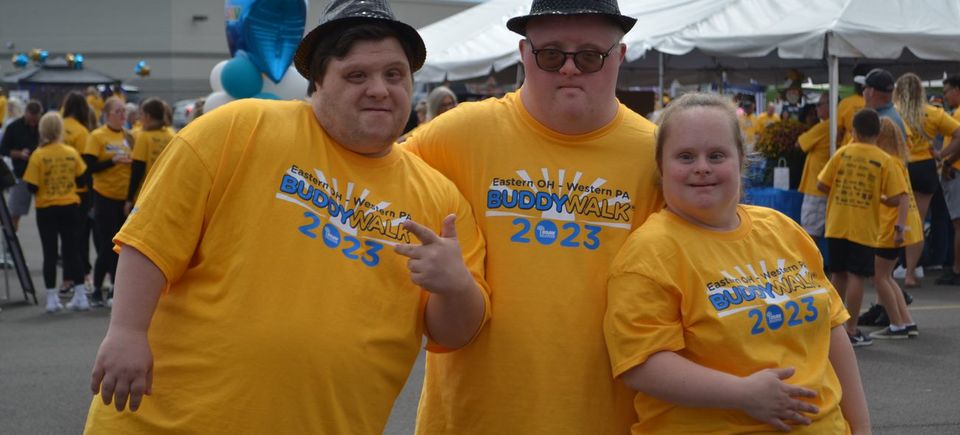 Three Buddy Walk participants wearing event shirts and posing together at the DSAV celebration.