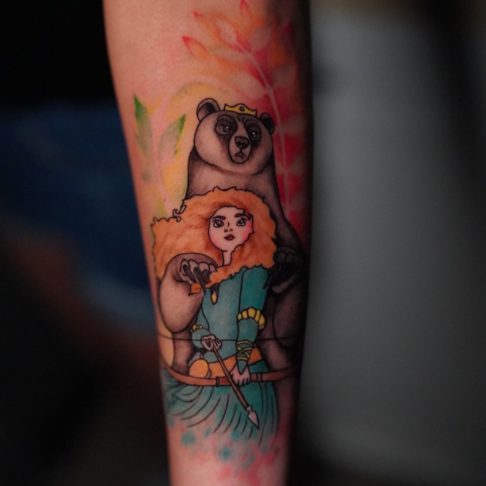Image of a tattoo of a woman and bear in colorful ink