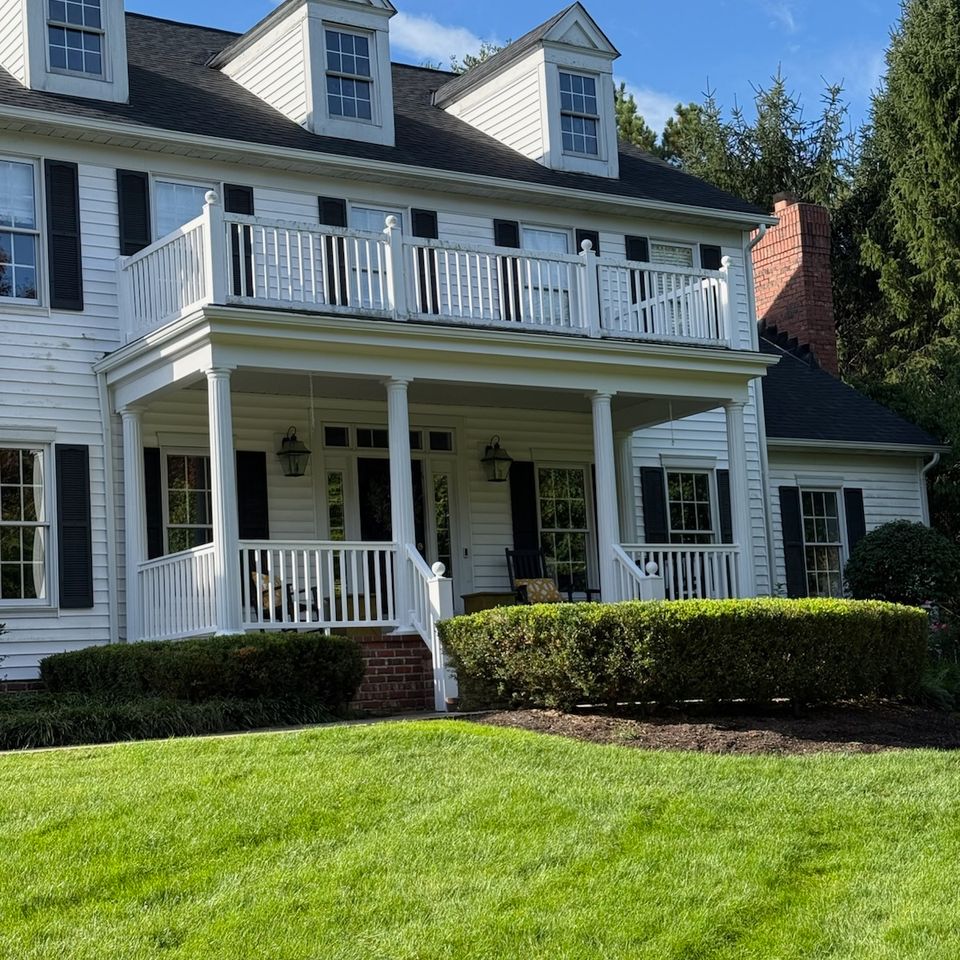 White colonial home with covered front porch and second-storey balcony remodeled on Cleveland's east side