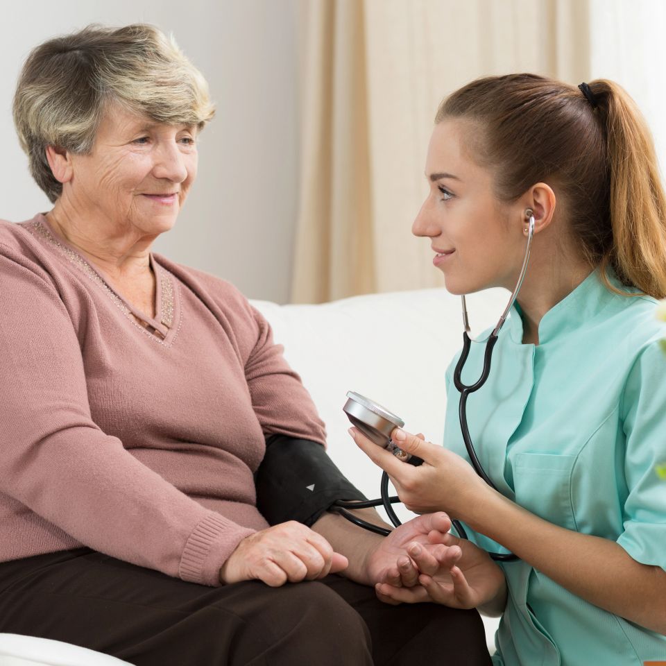 Nurse measuring blood pressure of her senior lady patient
