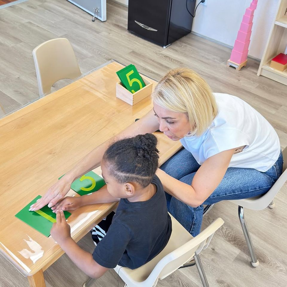 A teacher at Montessori Magic Key in Palmdale, CA helping a child learn