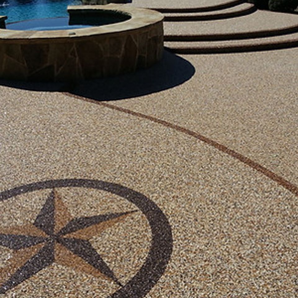 Pool deck finished with EverStone Flex flooring featuring a decorative compass design.