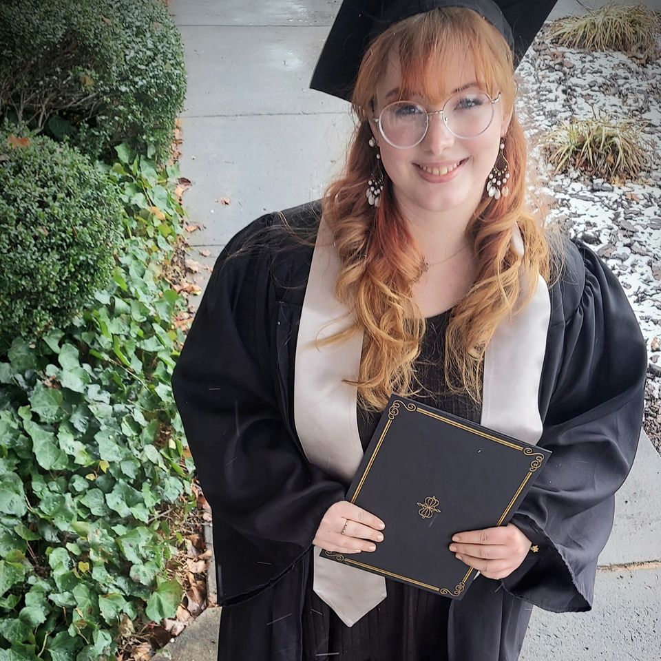 Beauty school graduate smiling with diploma after completing training
