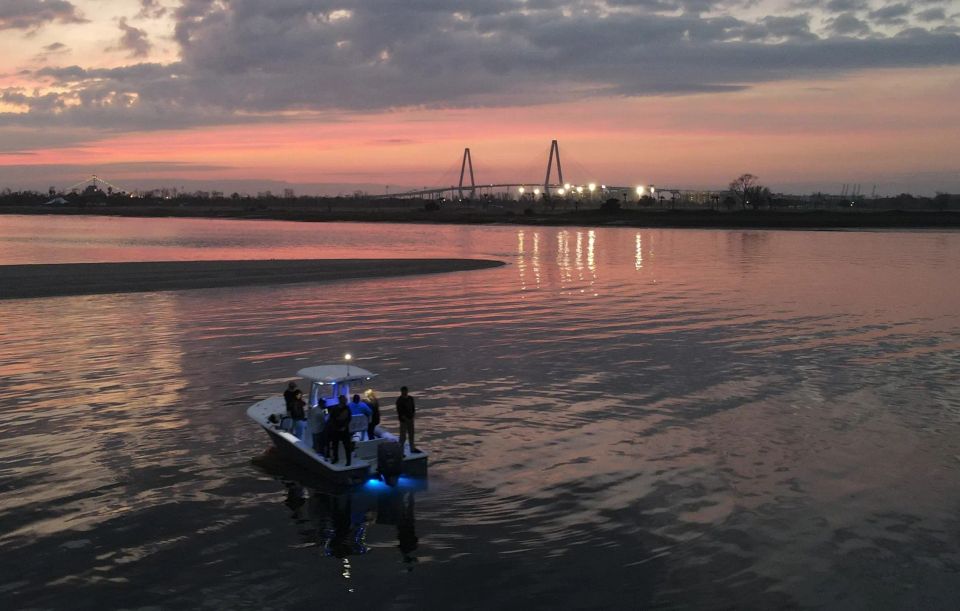 Small group on boat during Charleston sunset with Ravenel Bridge in background