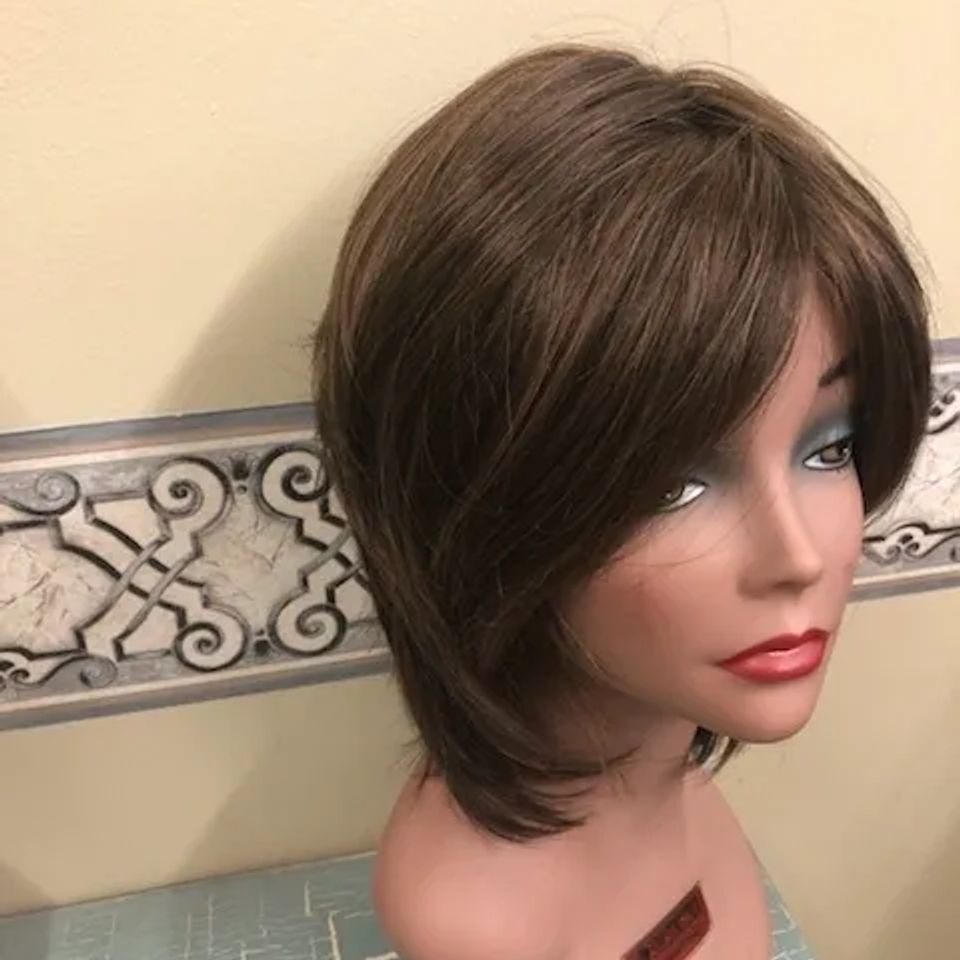 Shoulder-length brunette wig with side-swept bangs and layered styling displayed on a mannequin at Shears Wigs & Hairpieces Salon.