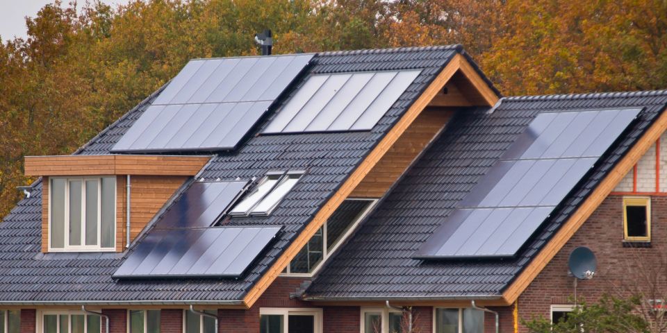 A stock image of a clean, professional solar panel installation on the roof of a modern home, used in a blog by Cannone Marketing.