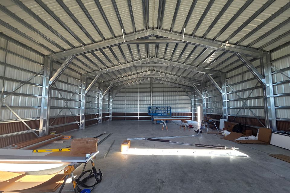 Finished metal building interior with clear span steel framing and poured concrete slab in Trout Creek MT
