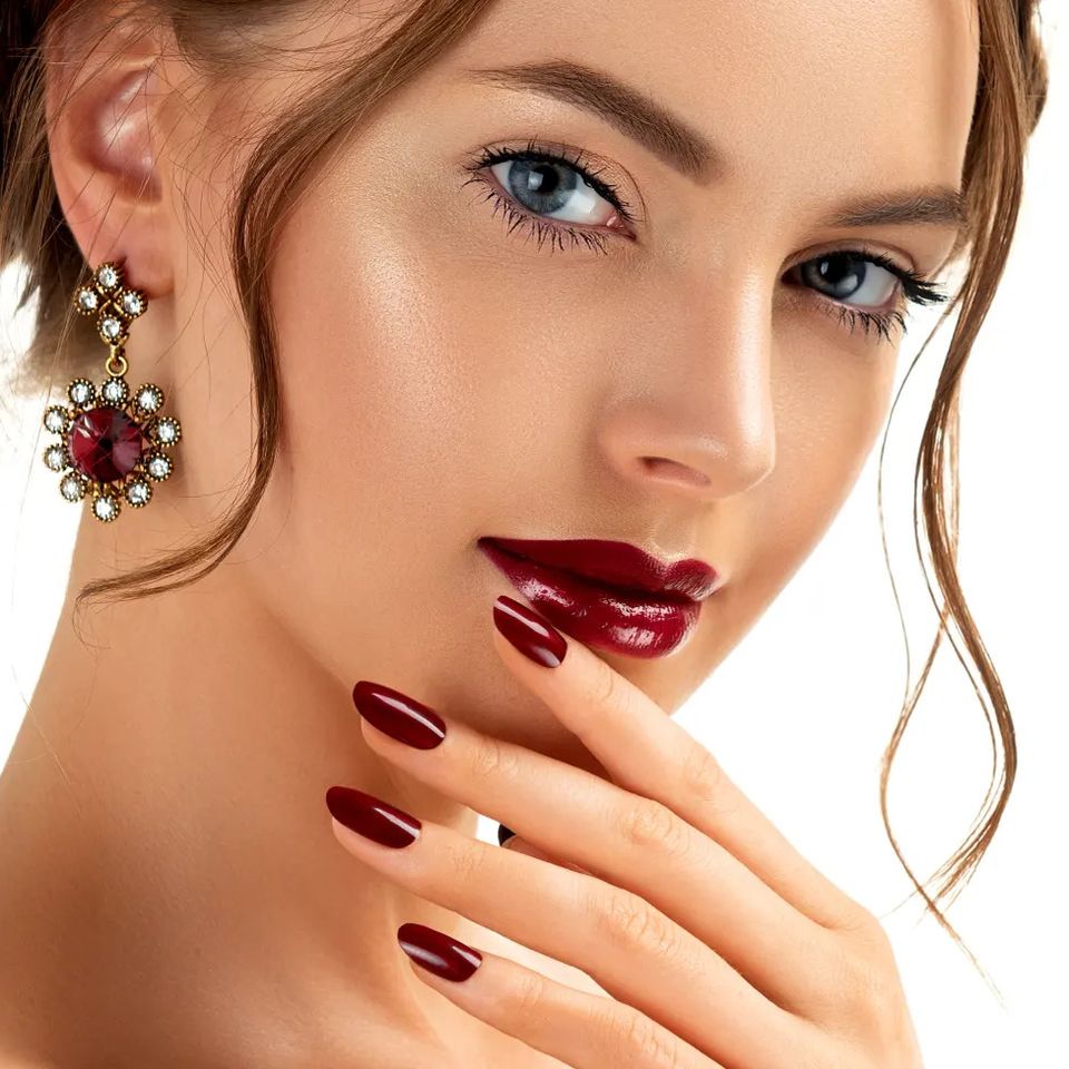 Woman with clear glowing skin and deep red manicure after Inner Beauty hydration IV therapy