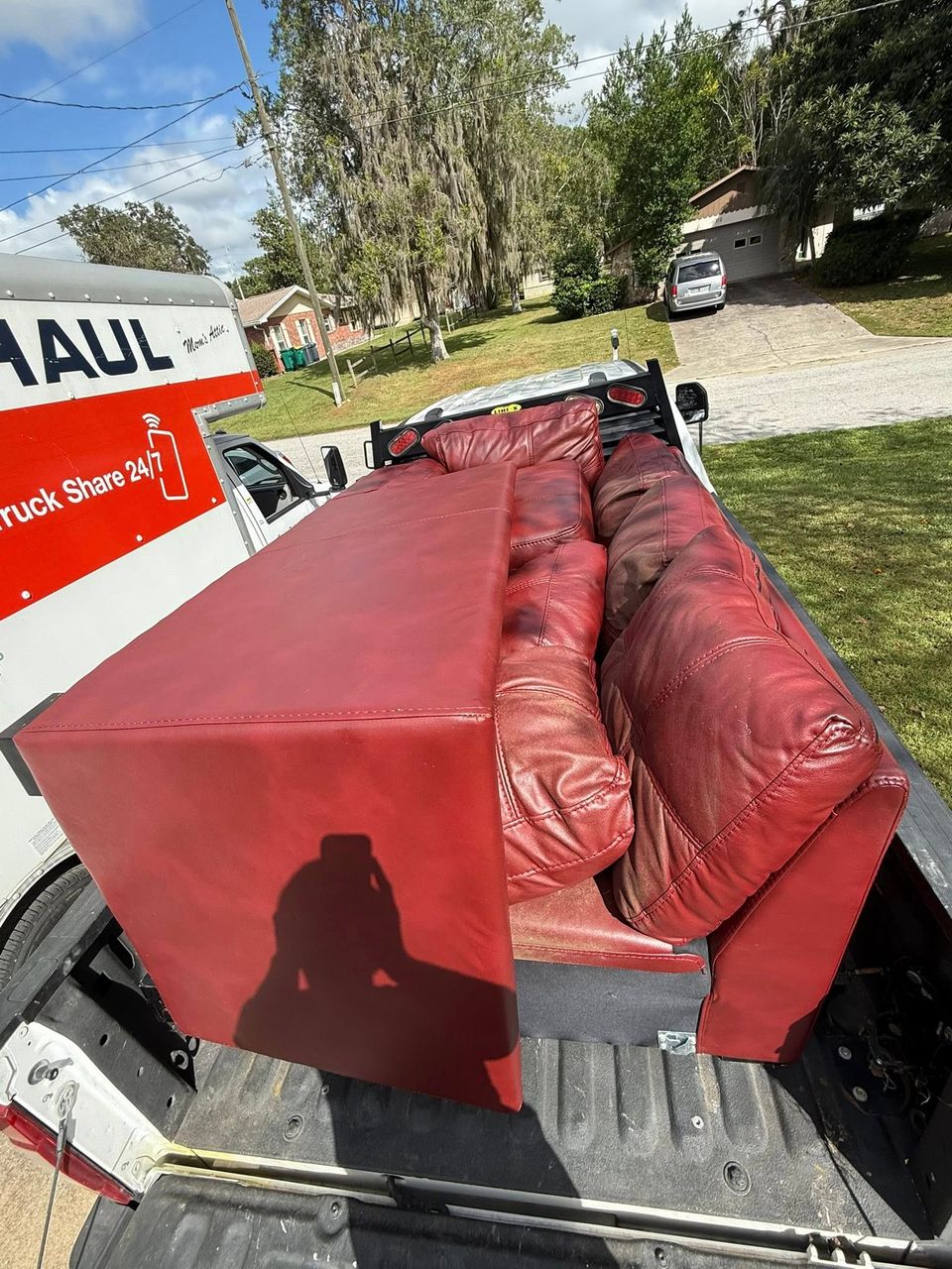 A red couch being transported by JNJ Hauling Solutions of Citrus County