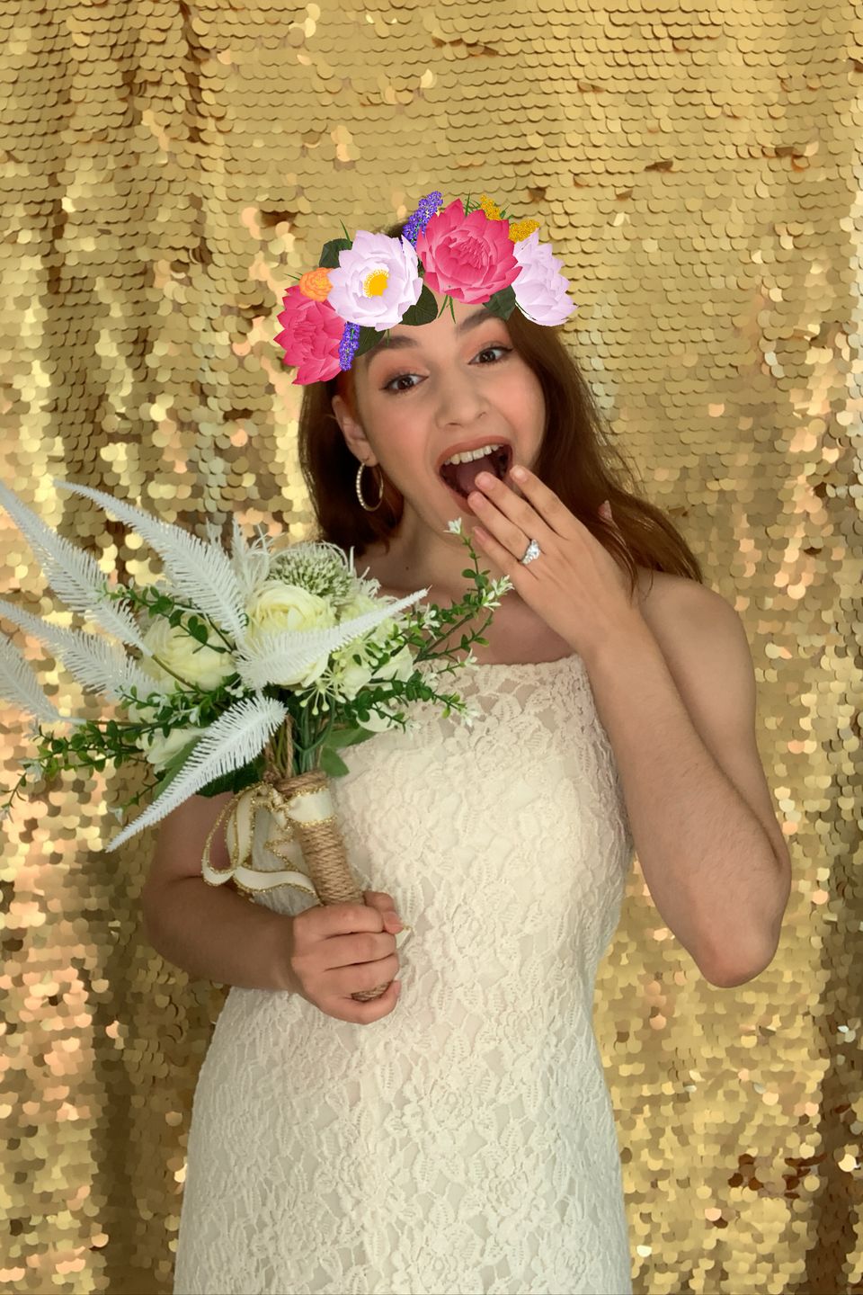 Woman in wedding dress smiling at a photo booth.