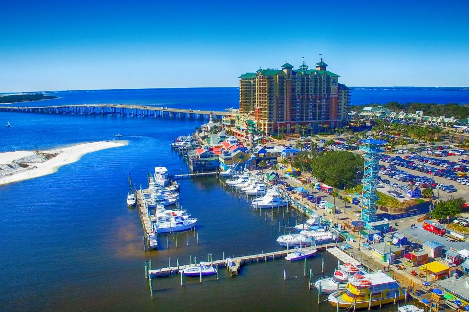 Aerial view of Destin Harbor with boat docks, waterfront shops, and the bridge over the bay