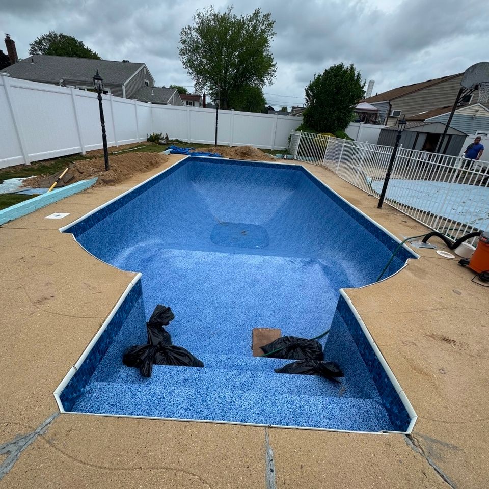Blue mosaic pool liner installed in an empty inground pool before filling on Long Island NY