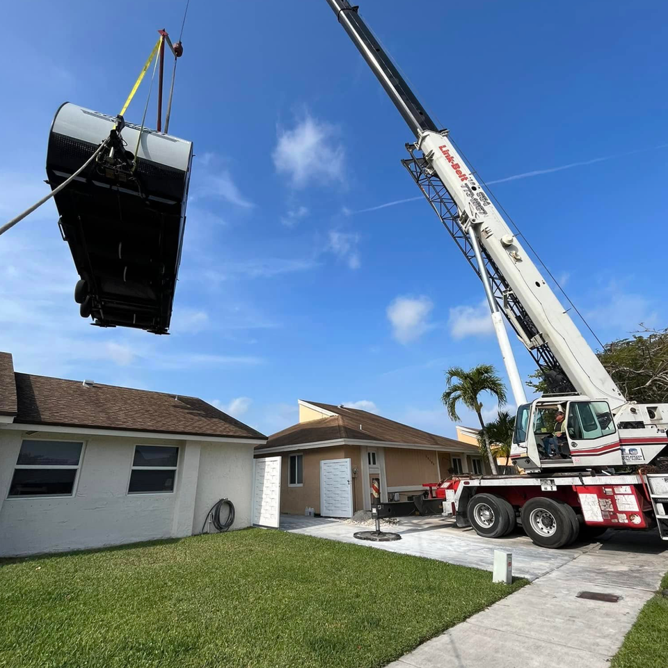 Lg crane service removing a camper from the house backyard