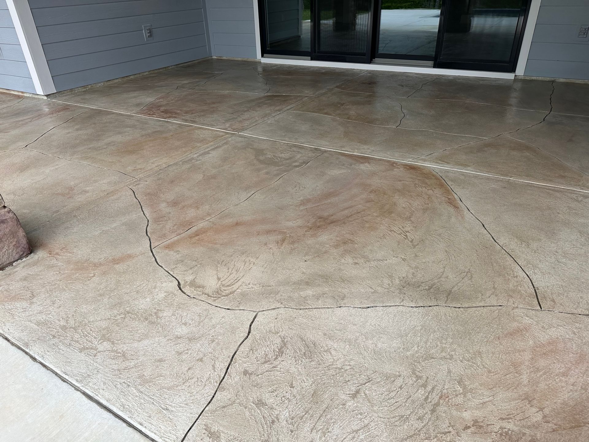 Completed decorative concrete patio in Savannah Lakes Village with custom overlay and warm earth tone finish