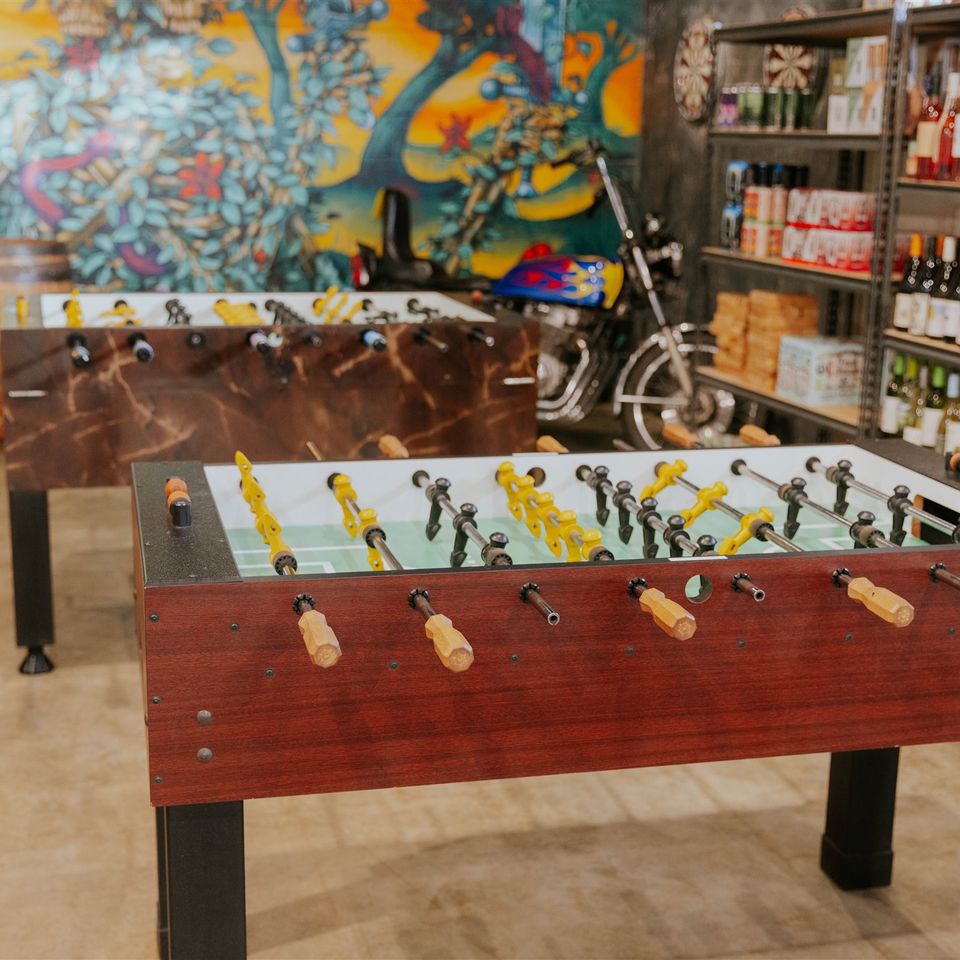Foosball tables with motorcycle in background