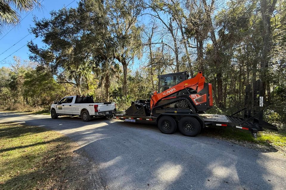 JNJ Hauling Solutions hauling a kubota with their truck