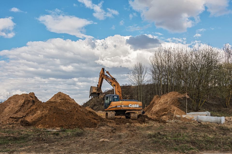 an earthworks project with a back ho digging up the dirt