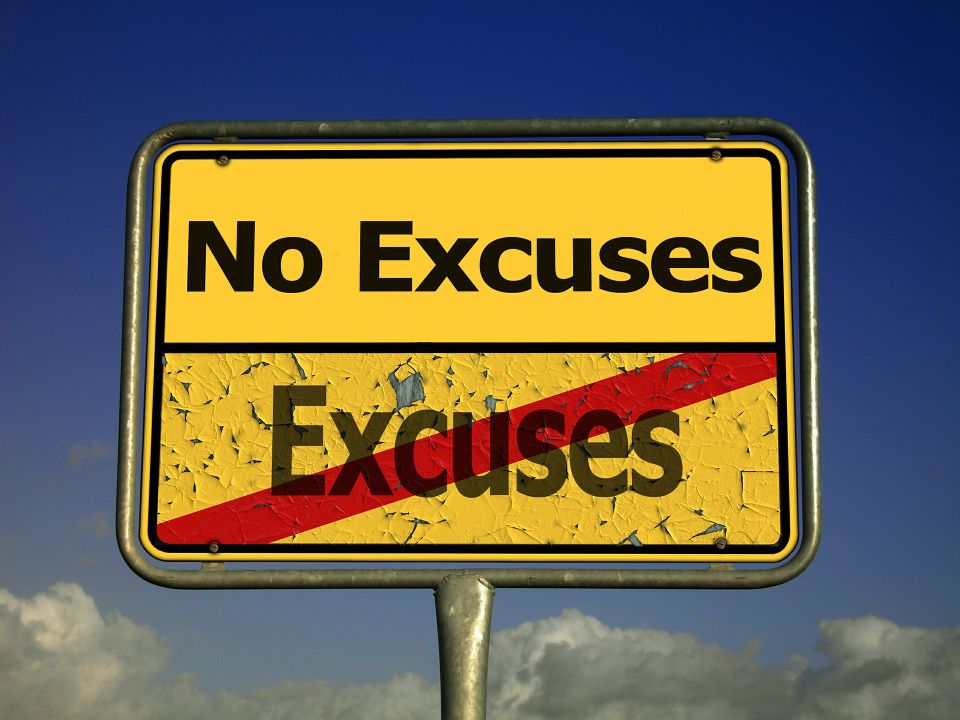 A yellow road sign with the text 'No Excuses' at the top and the word 'Excuses' crossed out in red below, set against a clear blue sky background.