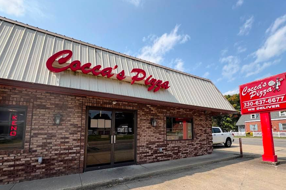 Cocca’s Pizza Cortland, Ohio location featuring a brick exterior, glass double-door entrance, and large red Cocca’s Pizza sign above the entrance.