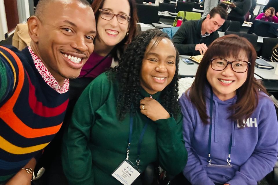 One man and three women smiling for photo