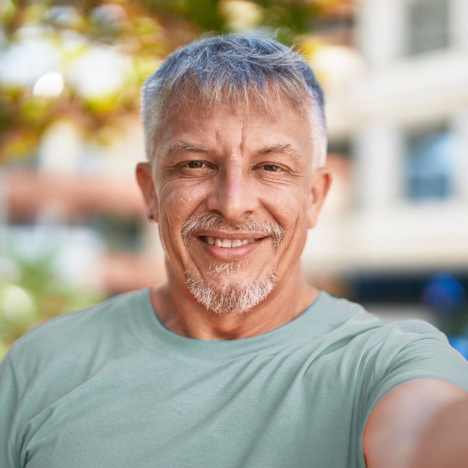 “Smiling middle-aged man outdoors, representing confidence, hope, and a fresh start.”