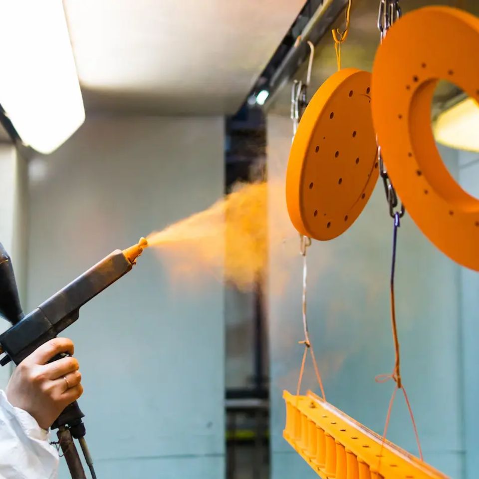 Vistacreate 189241482 stock photo powder coating of metal parts a woman in a protective suit sprays powder paint from (1)