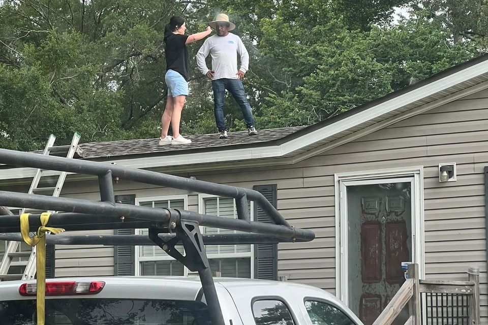 A Teal Roofing manager inspecting a roof with a worker.