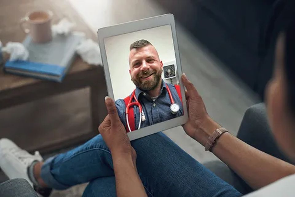 Patient holding a tablet during a telehealth visit with be well berlin provider  representing virtual healthcare access.