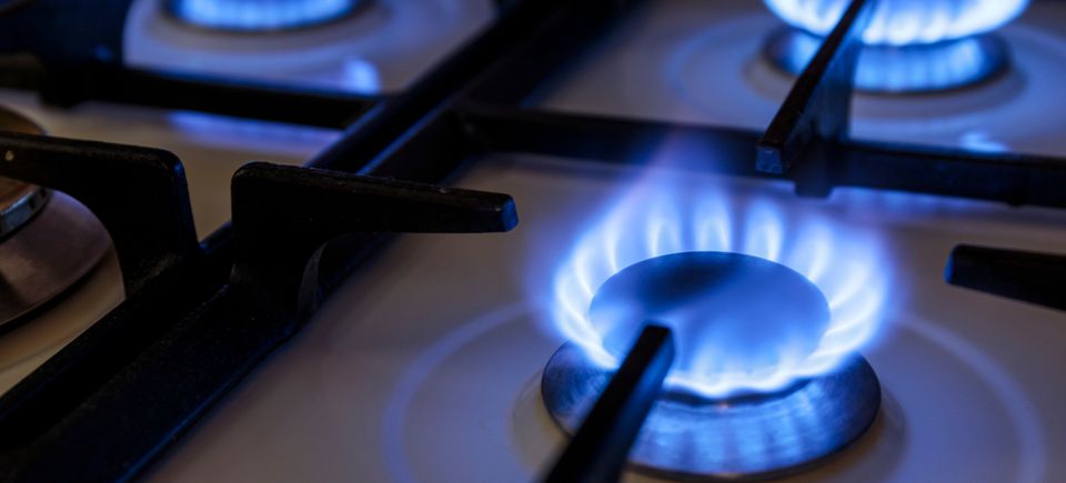 Blue flame on a gas stove burner demonstrating propane's efficiency for residential cooking.