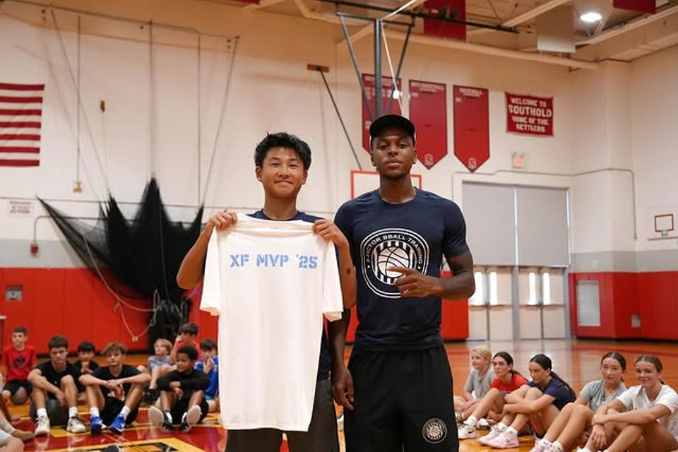 Xavier Allen posing with a student holding up a t-shirt