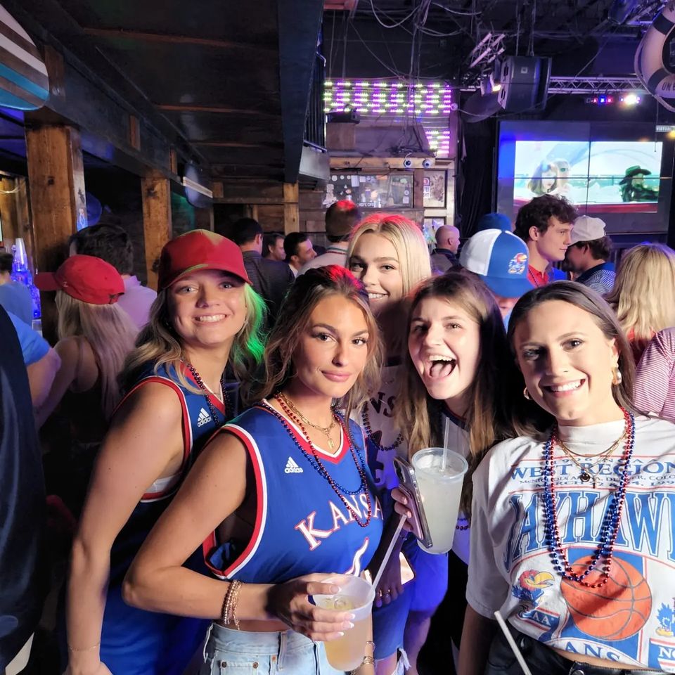 Several college female co-eds enjoy their time at the Kansas Jayhawks basketball pre-game event on Bourbon Street.
