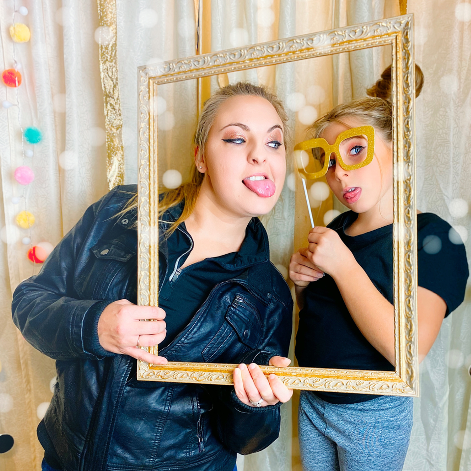Two people using props and frame during a photo booth session.