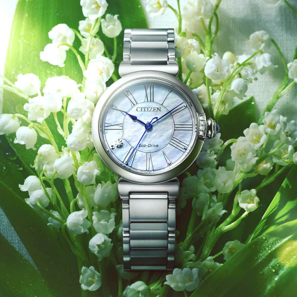 Citizen Watch laying on lily of the valley flowers.