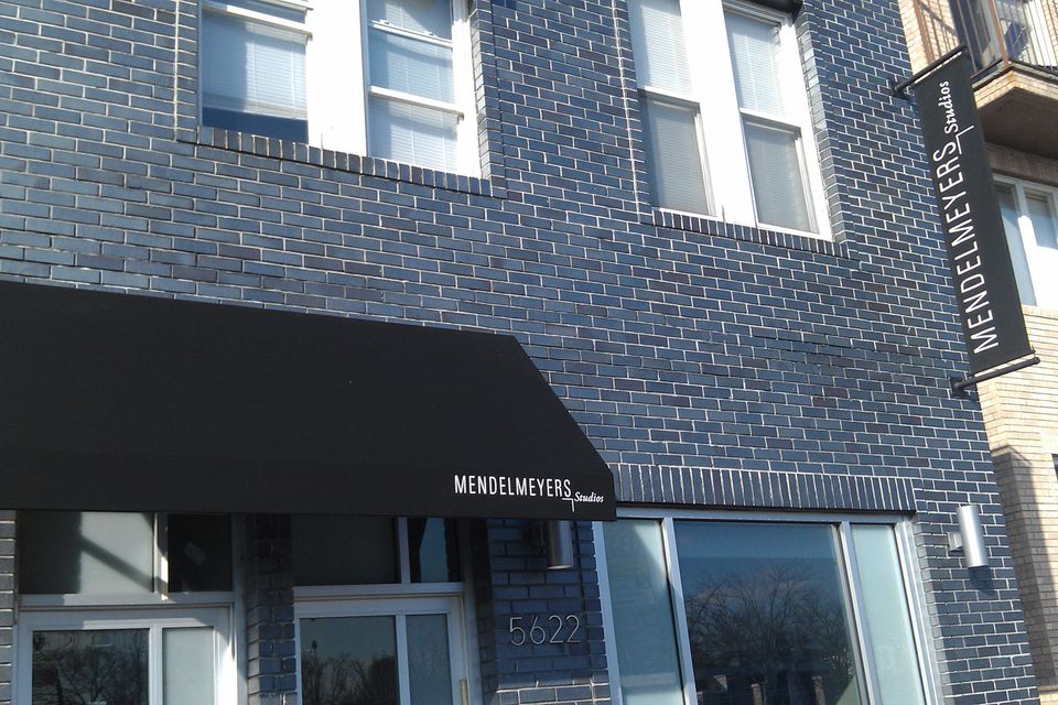 Black shed awning with white lettering and a matching projecting sign.