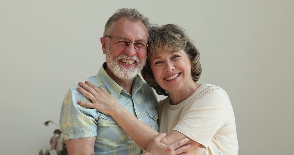 Family portrait happy loving aged couple embracing looking at camera sbi 349995281