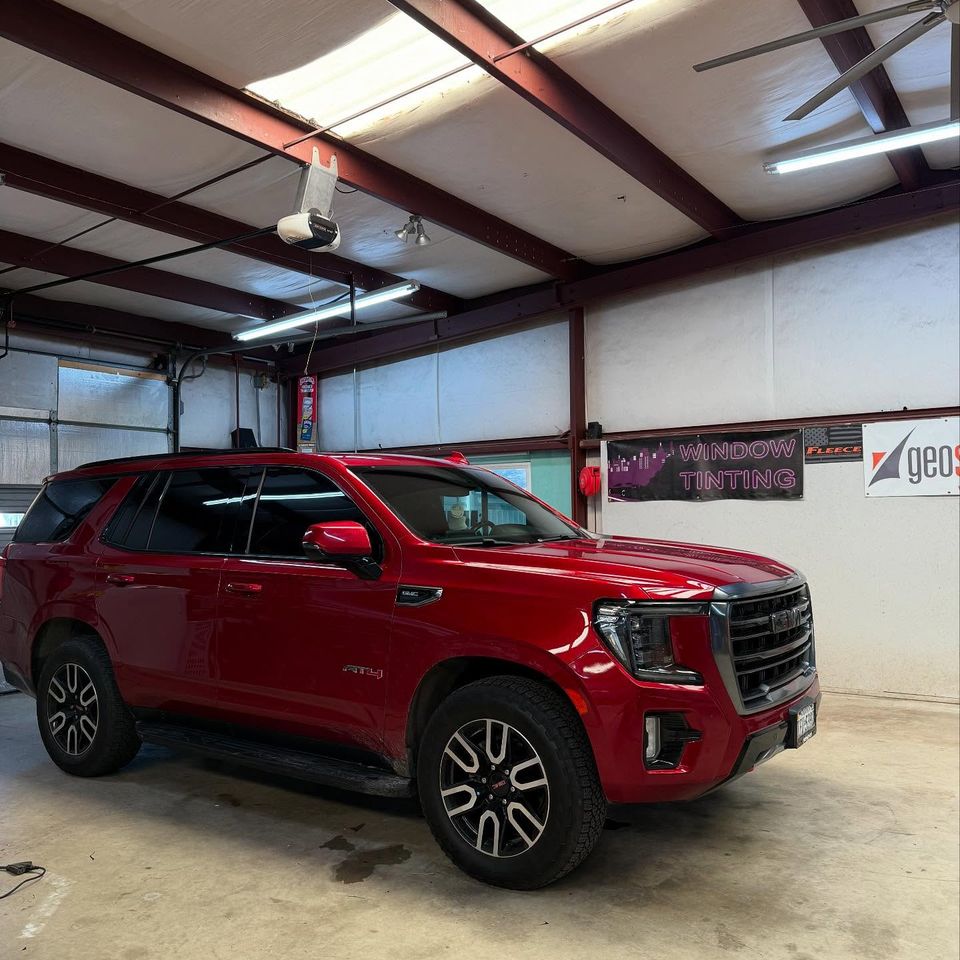 Red GMC Yukon AT4 with dark tinted windows after auto tint in Moyock NC