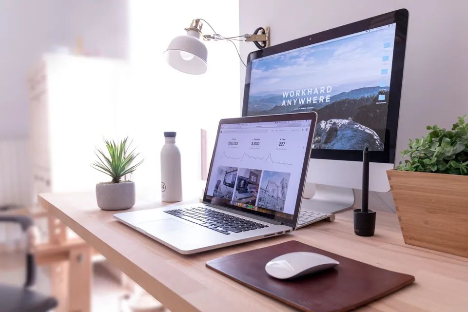 home office desktop with a laptop in front of a desktop computer, seen from the right