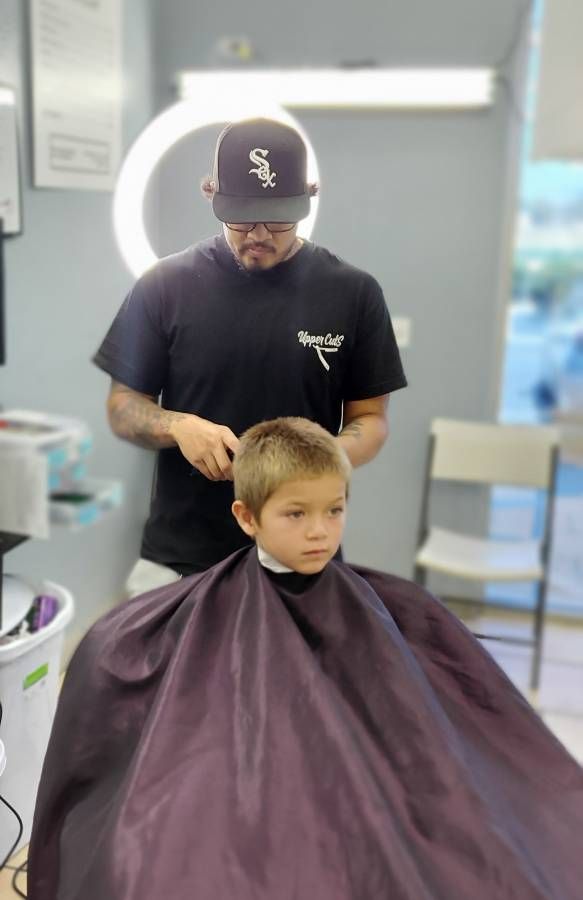 Barber with young boy client receiving a haircut