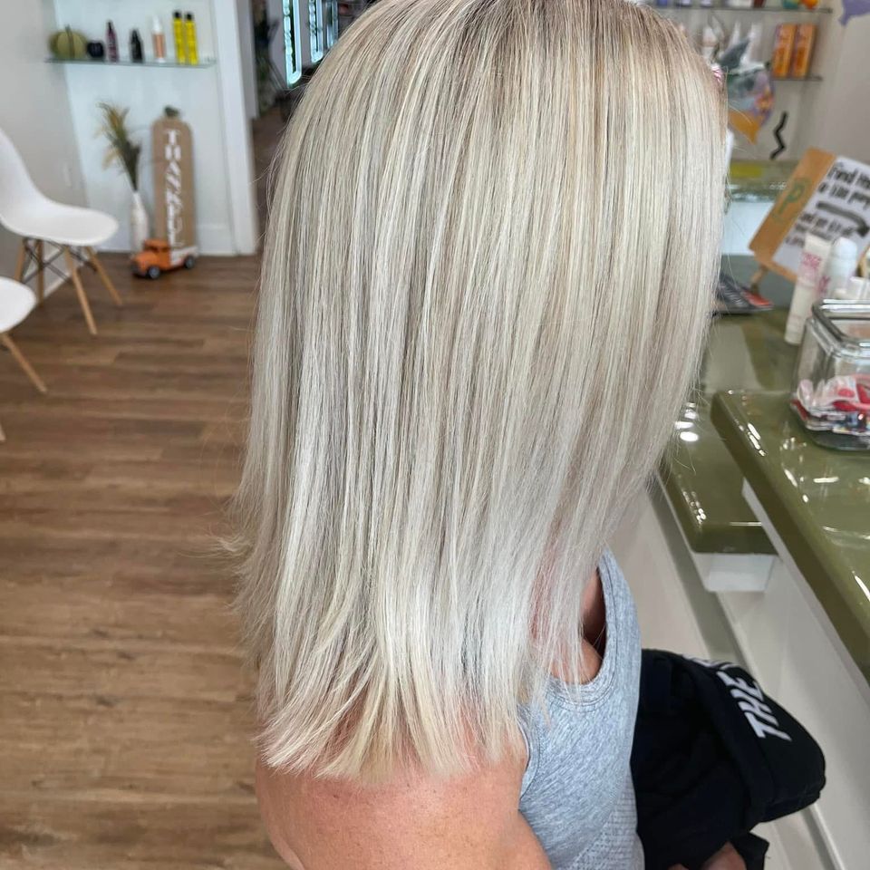 Long straight platinum blonde hair with smooth finish after color and styling in Columbiana AL