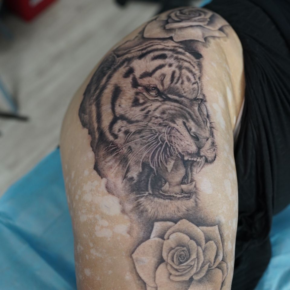 Image of a tiger's head in black and white with a flower below and above him
