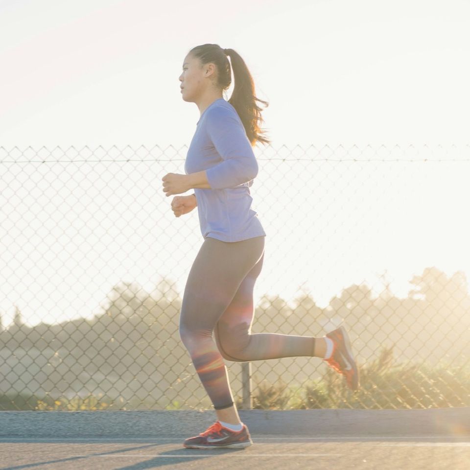 Woman with sustained energy running on a track after a Get Up & Go IV boost