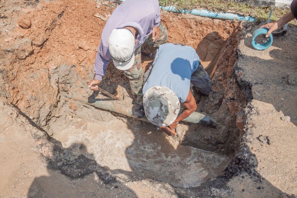 Underground utility contractors fixing a pipe