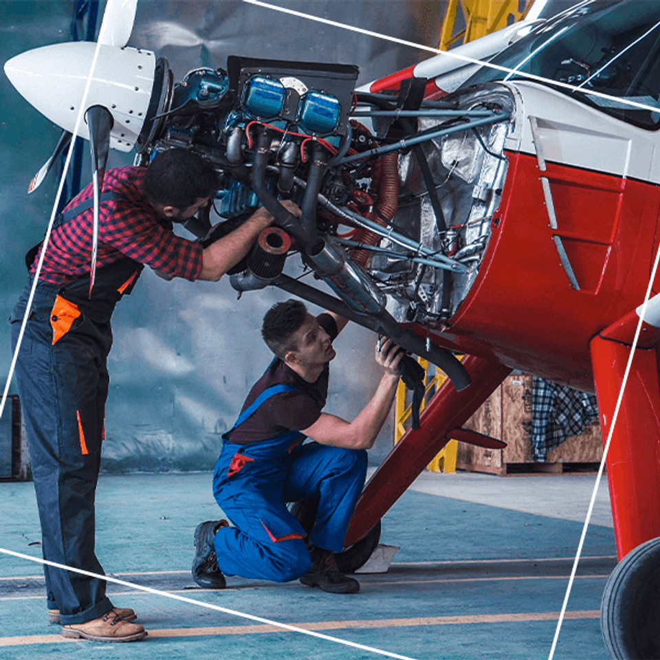 Two men in overalls repairing plane